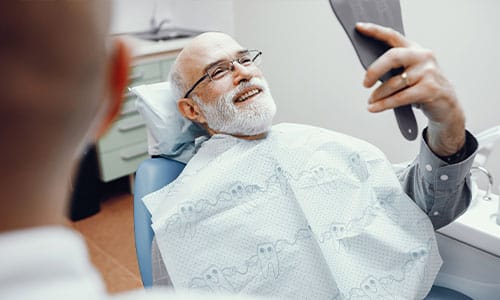 old man smiling after dentures